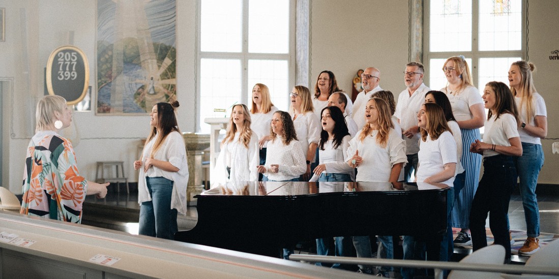 Körmedlemmarna står uppställda i vita tröjor.